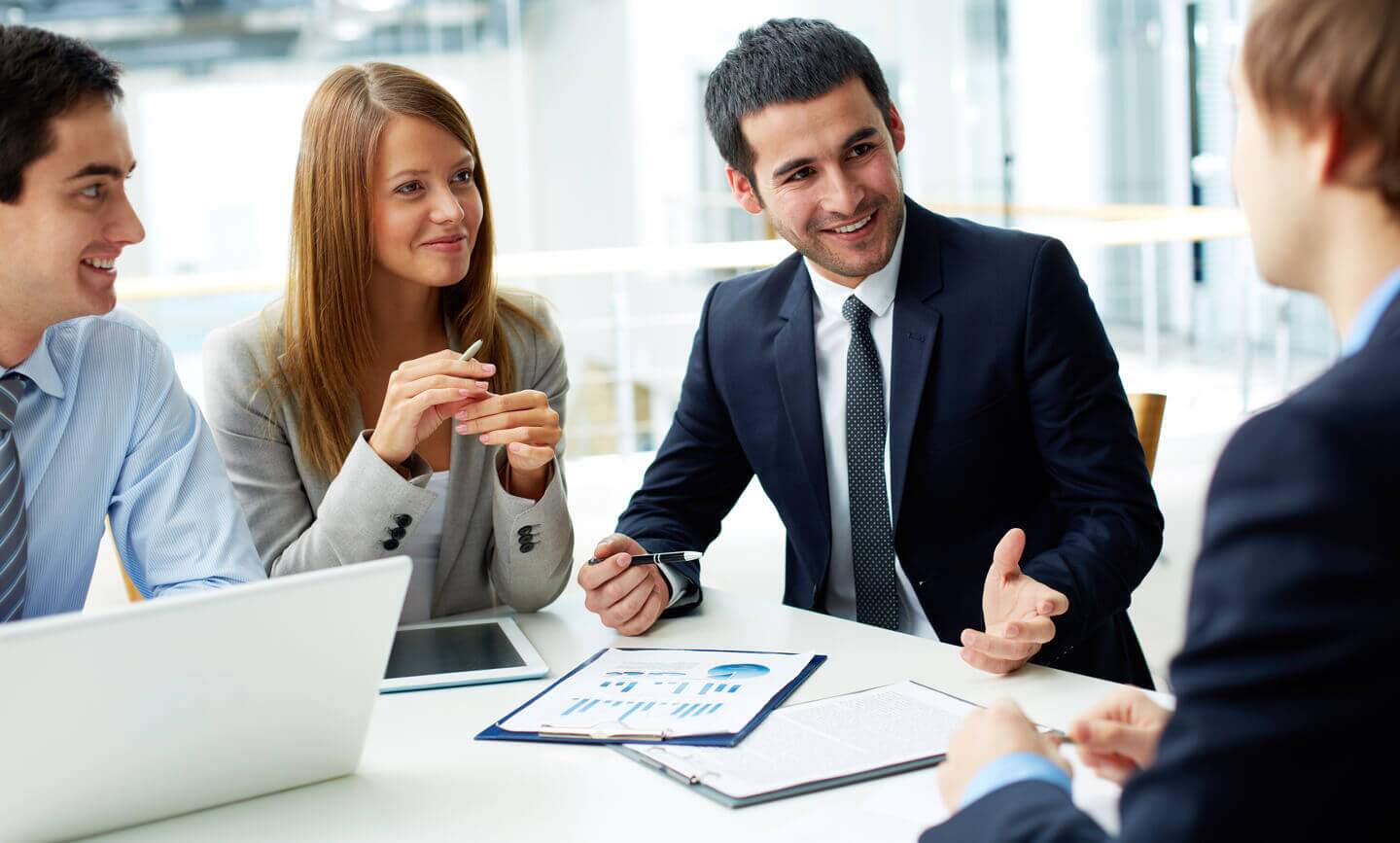Grupo de consultores frente a una mesa conversando de trabajo
